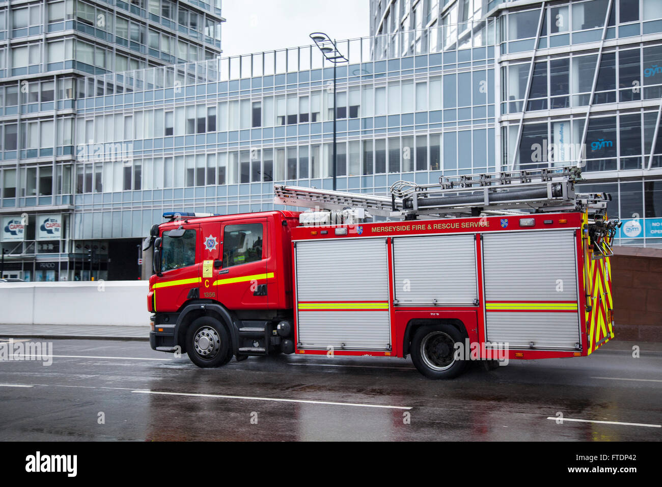 Merseyside Fire & Rescue appliance, fire truck, emergency  vehicle, rescue, firefighter, safety, engine, red, transportation, equipment, transport, fireman, danger, department, service firetruck, responding to an emergency on The Strand, Liverpool, UK Stock Photo