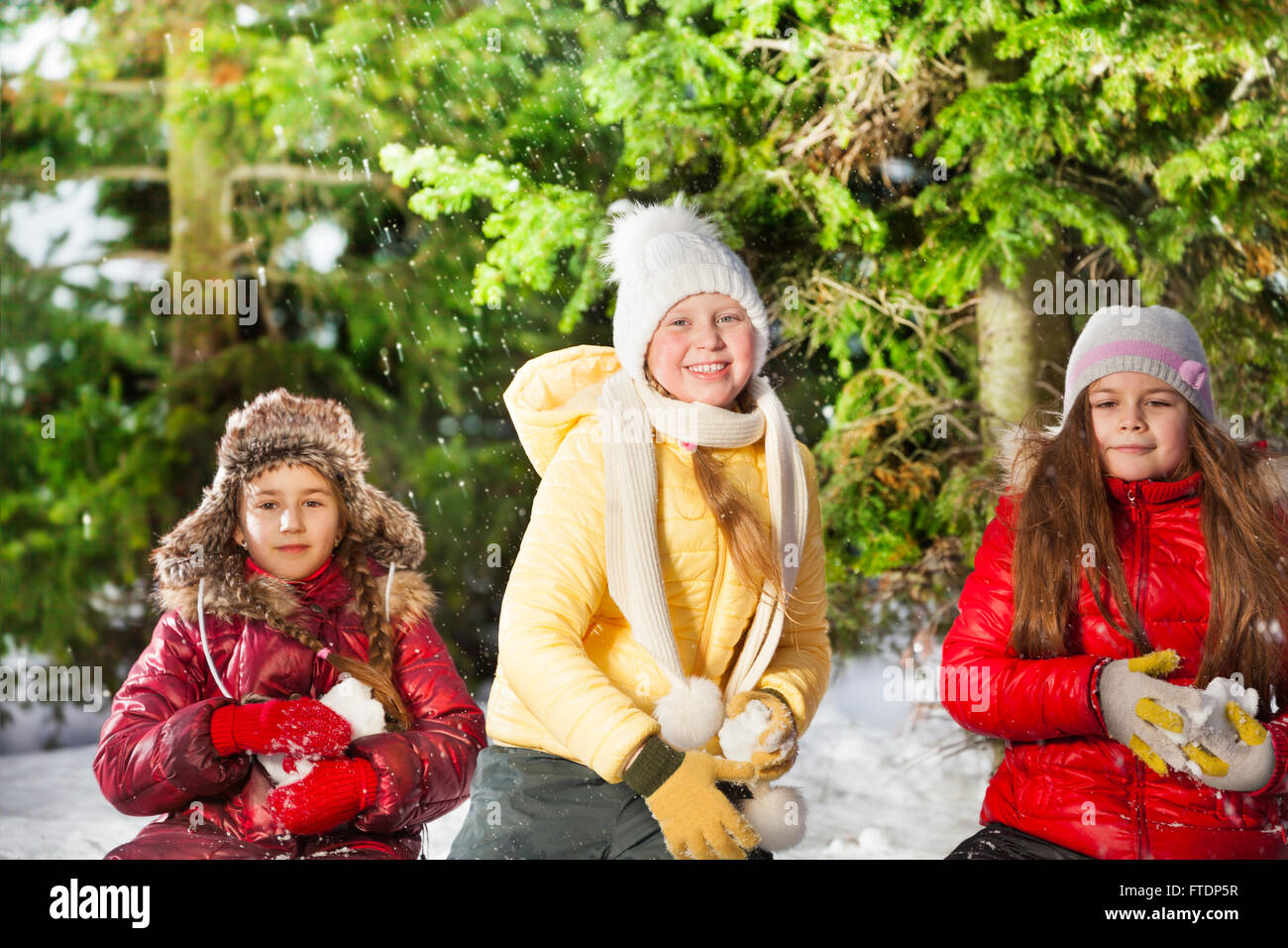 Three girls snowball fighting in the winter forest Stock Photo