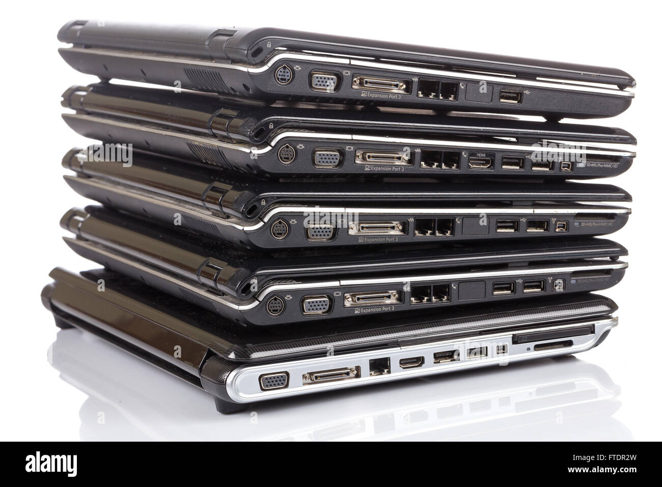 stack of old laptops awaiting repair isolated on white background Stock