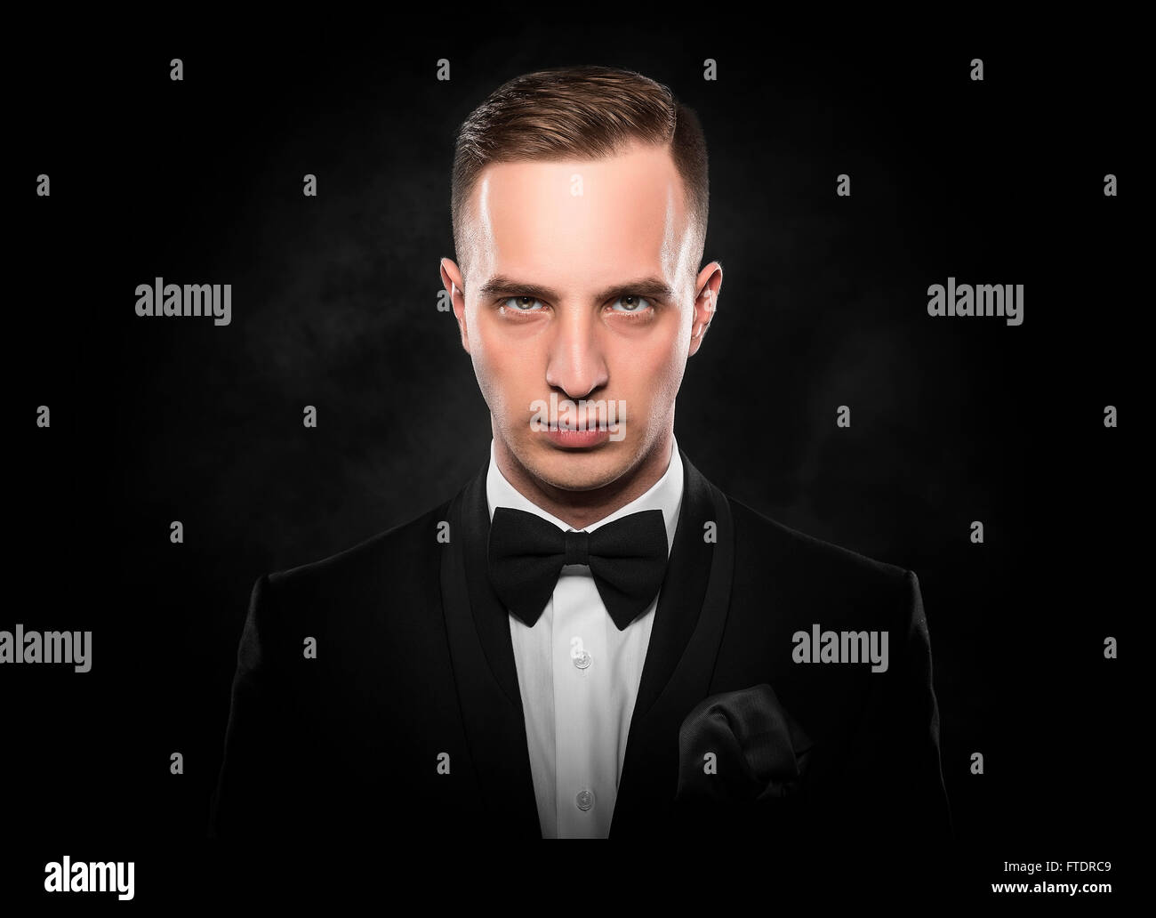Young handsome man in black suit on dark background Stock Photo - Alamy