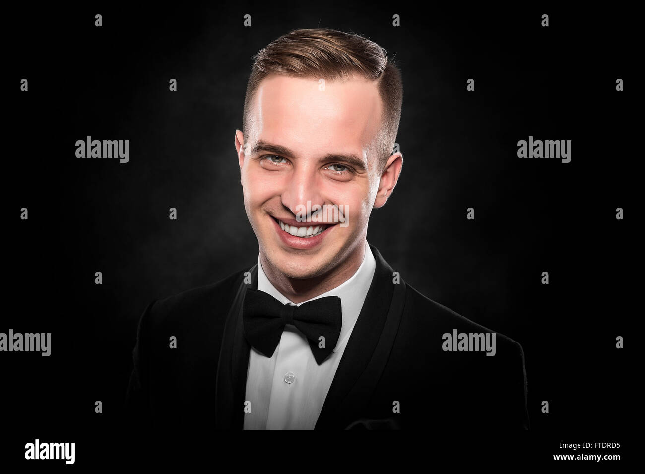 Young handsome man in black suit on dark background Stock Photo - Alamy