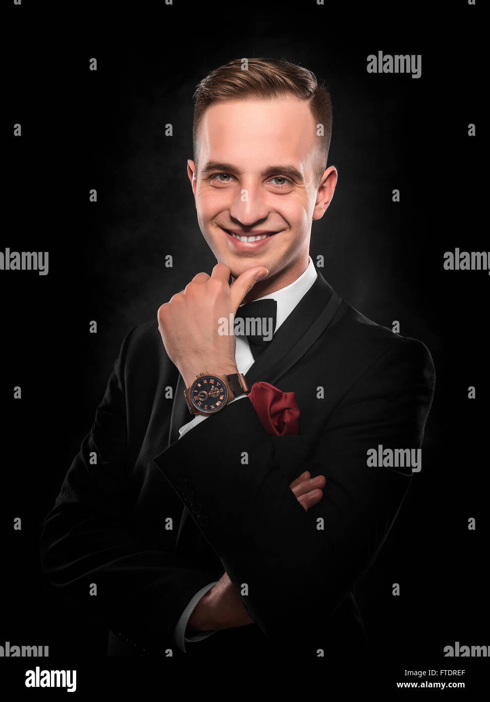 Young handsome man in black suit on dark background Stock Photo - Alamy