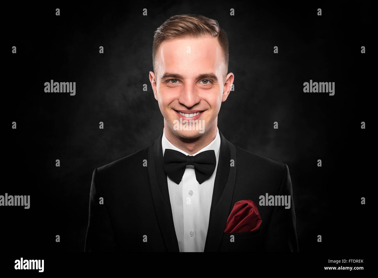 Young handsome man in black suit on dark background Stock Photo - Alamy