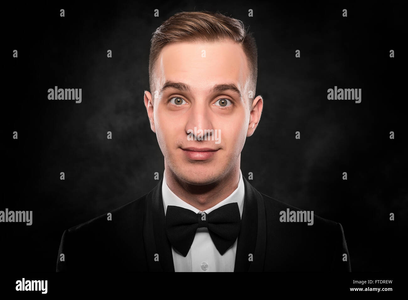 Young handsome man in black suit on dark background Stock Photo - Alamy