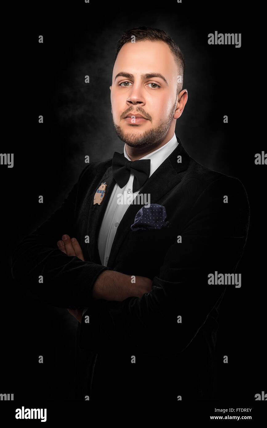 Young handsome man in black suit on dark background Stock Photo - Alamy