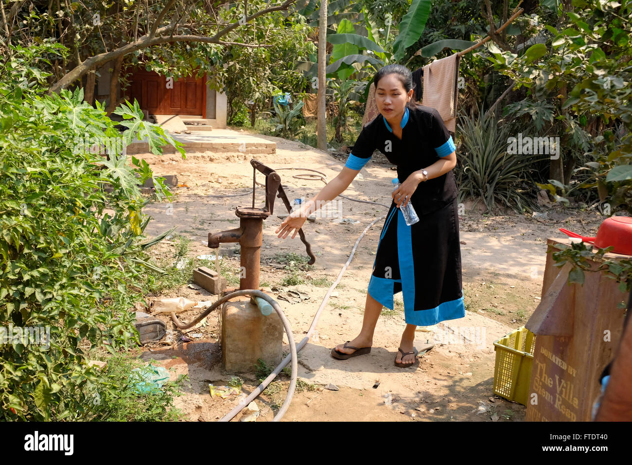 Guide in Siem Reap, Cambodia demonstrating how villagers get their water, which is brown and must be boiled Stock Photo