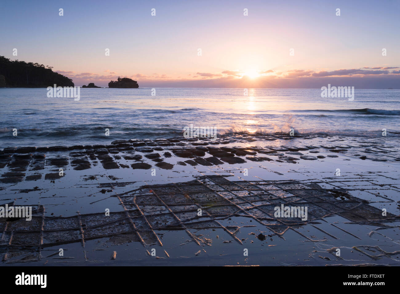 Atmospheric sunrise at Tessellated Pavement, Eaglehawk Neck, Tasman Peninsula, Tasmania, TAS, Australia Stock Photo