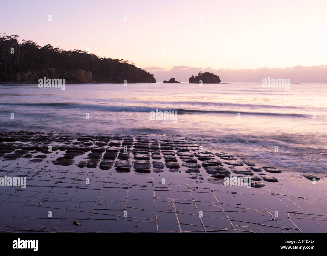 Atmospheric sunrise at Tessellated Pavement, Eaglehawk Neck, Tasman Peninsula, Tasmania, TAS, Australia Stock Photo