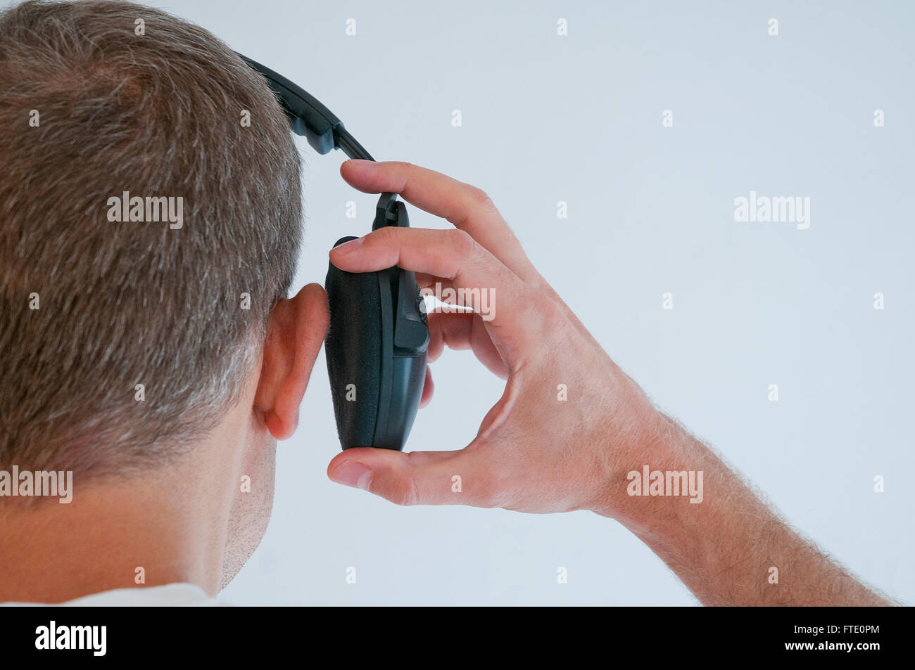 Man taking his earphone off. Close view. Stock Photo