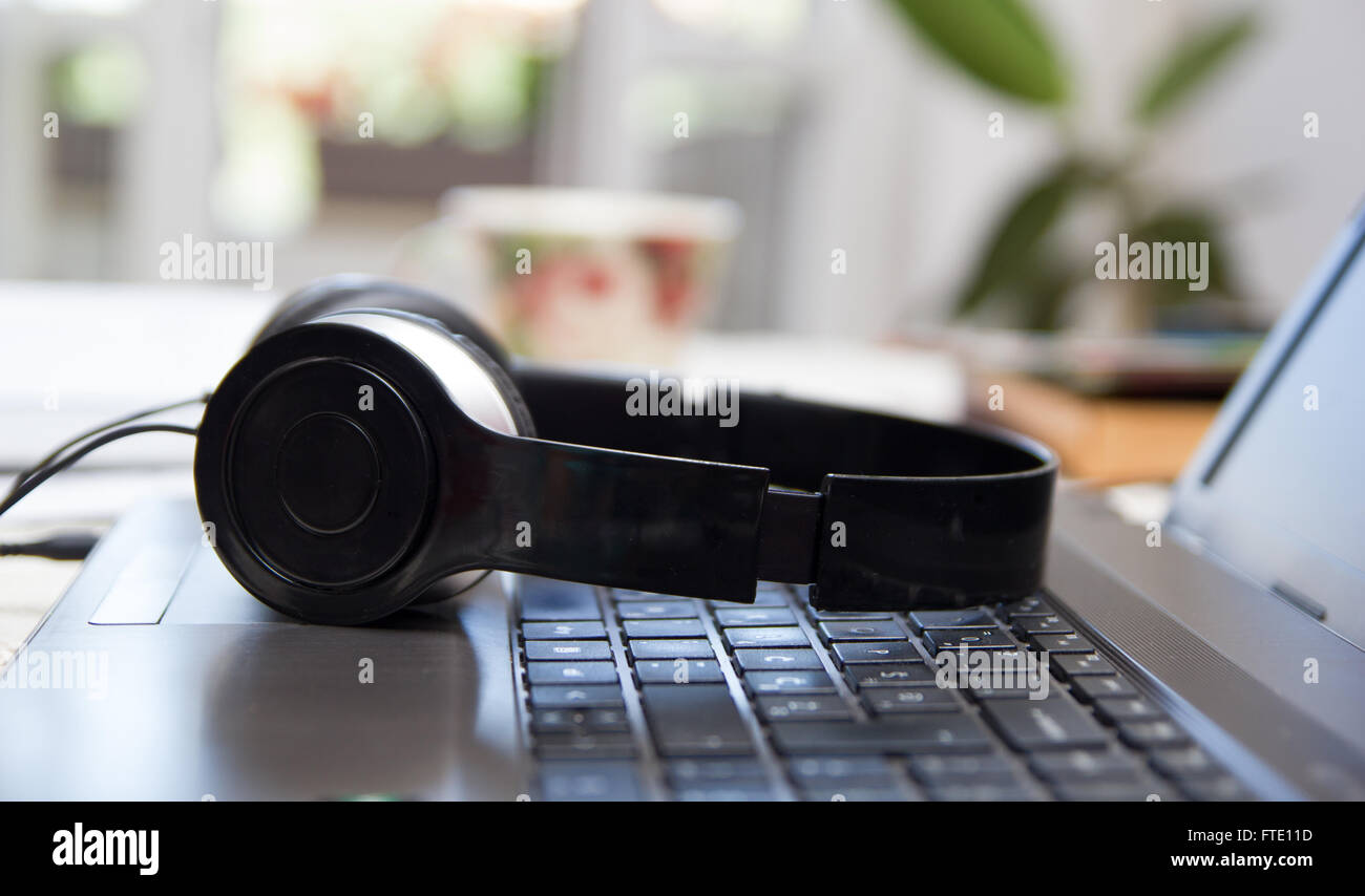 Headphones on laptop keyboard Stock Photo Alamy