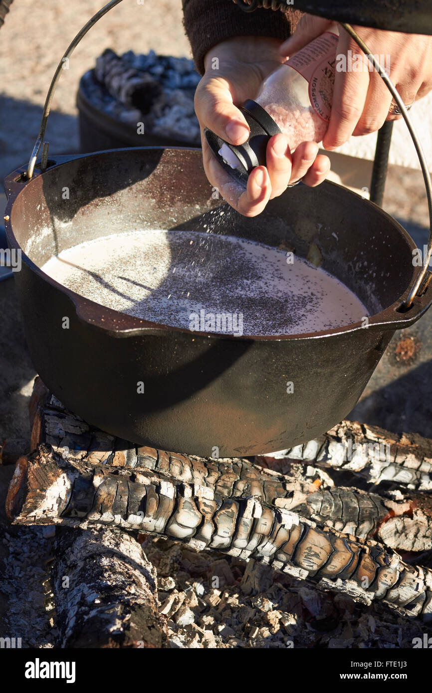 cook grinding pepper into a cast iron pot, traditional cowboy style cooking, farmer's market, Alpine, Texas, USA Stock Photo