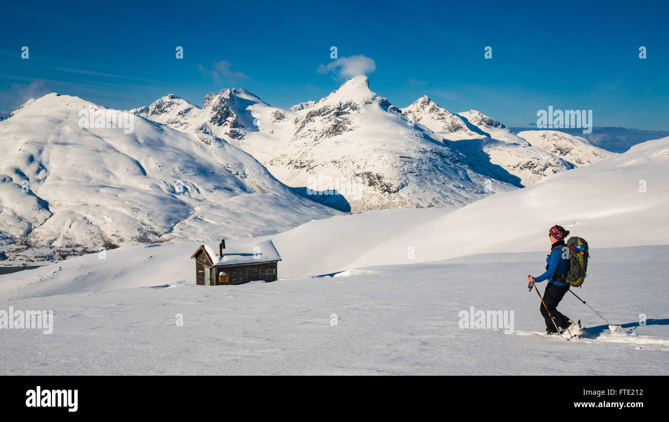 Ski touring towards cabin on Rodtinden with views towards Store Blamann and the open ocean, Kvaloya Troms, Northern Norway Stock Photo