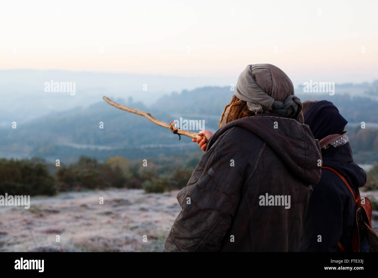 Two pilgrims looking at the sunrise in a cool and hazy morning Stock Photo