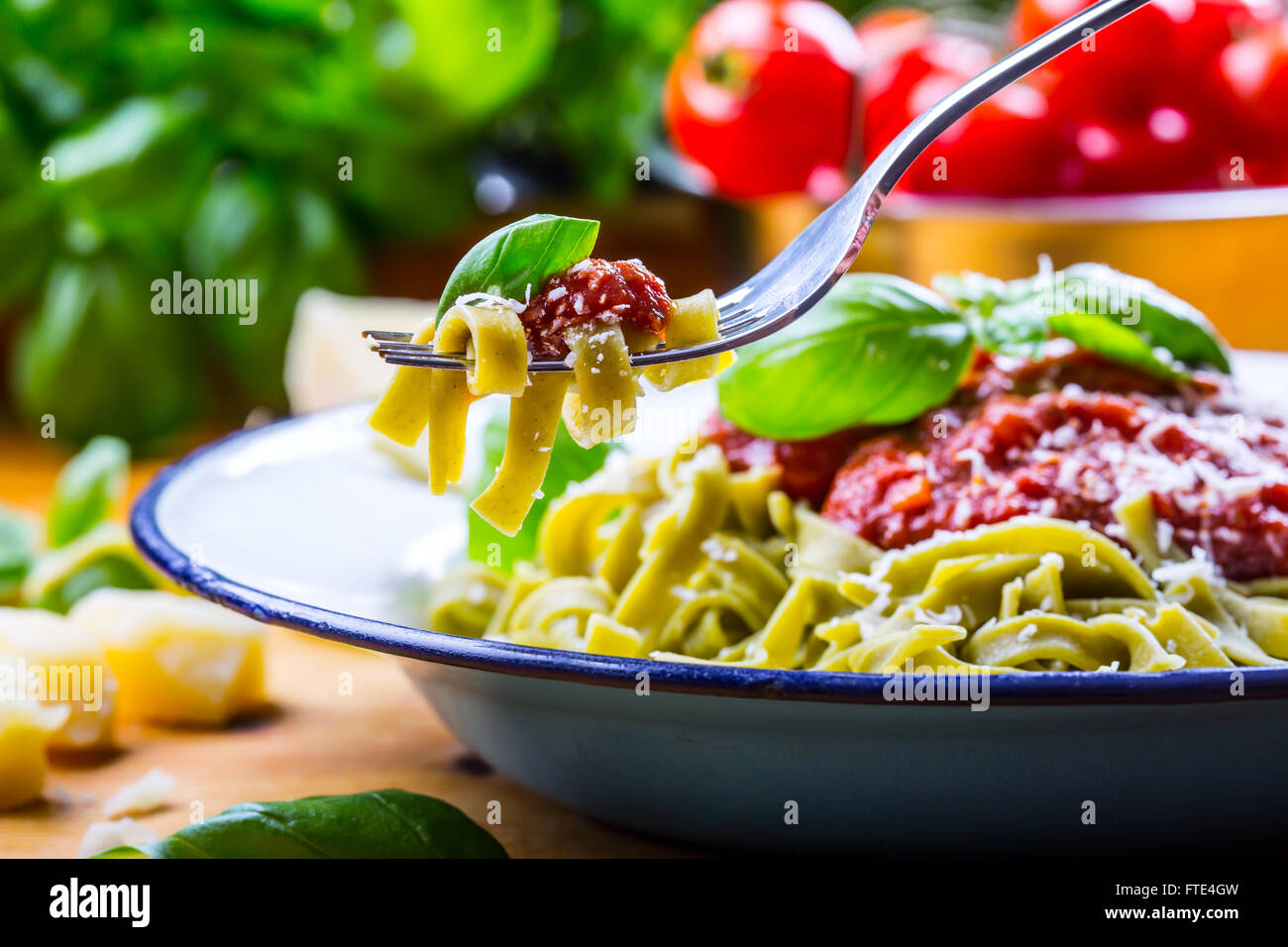 Pasta. Italian and Mediterranean cuisine. Pasta Fettuccine with tomato sauce basil leaves garlic and parmesan cheese. Stock Photo