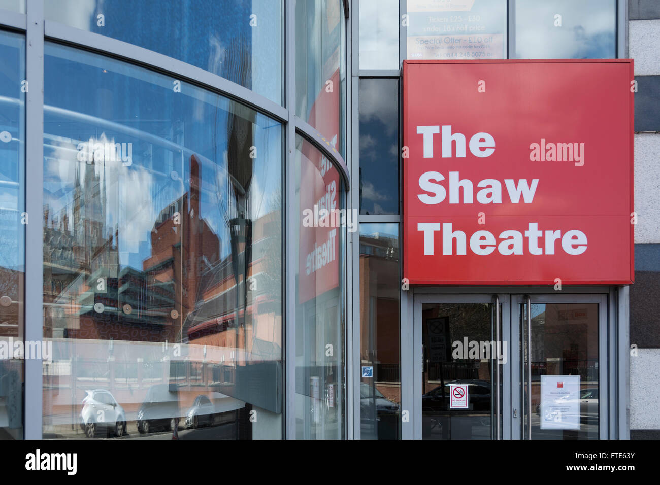 The British Library and St. Pancras railway station reflected in the window of the Shaw Theatre, Euston Road, London, UK Stock Photo