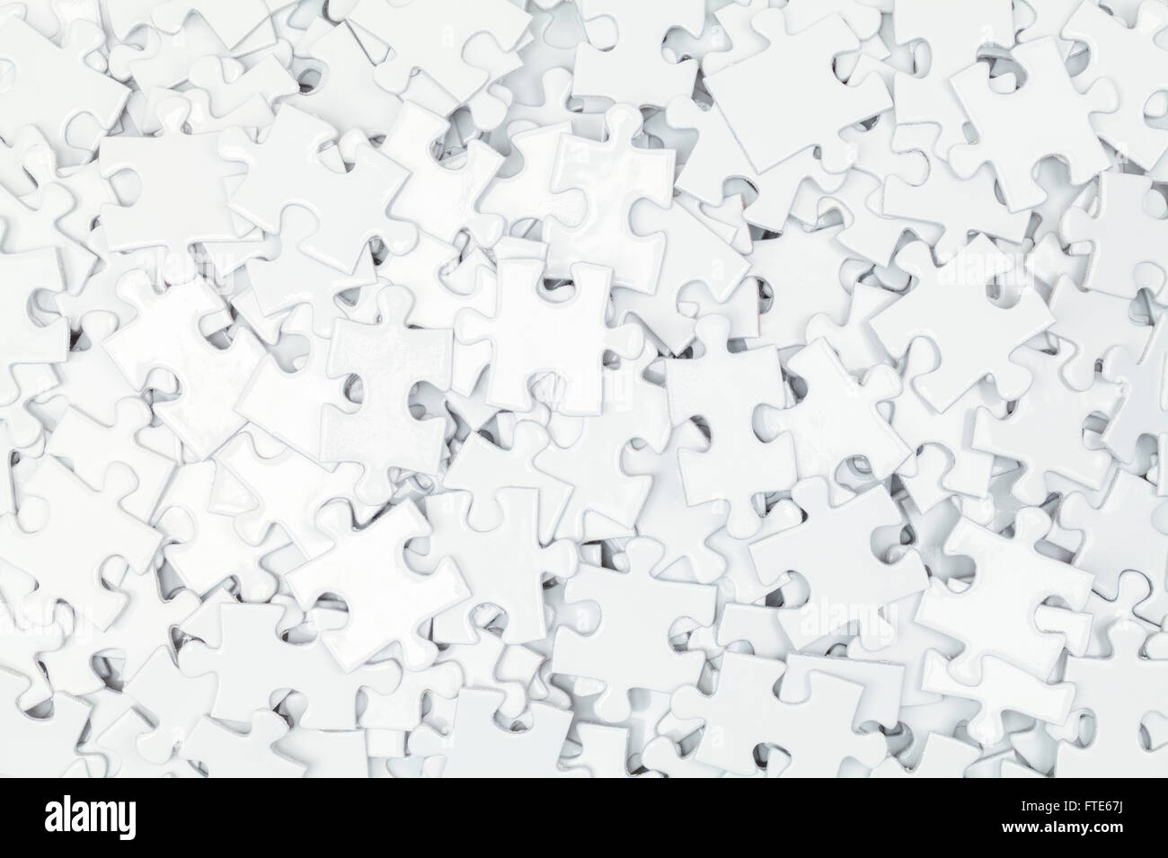 Pile of White Blank Puzzle Pieces Background. Stock Photo