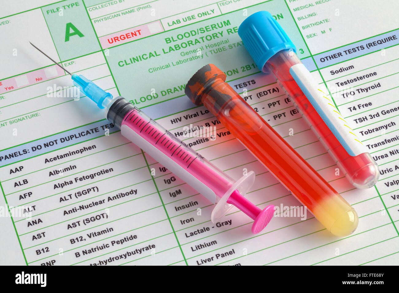 Blood Vials and Syringe with Needle on Top of Lab Results Stock Photo