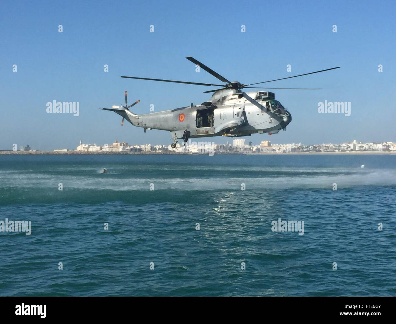 151119-N-ZZ999-775 NAVAL STATION ROTA, Spain (Nov. 19, 2015)  Sailors from Explosive Ordnance Disposal Mobile Unit 8, German navy Minetaucher Kompanie and Spanish Navy Unidads Buceadores MCM jump from a Spanish Navy helicopter into Cadiz Bay off the coast of Rota, Spain, as part of Exercise MAGRE 2015-2, Nov. 19. Exercise MAGRE is a tri-lateral counter improvised explosive device exercise involving Sailors from the U.S. Navy, German navy and hosted by the Spanish navy. (U.S. Navy photo by Explosive Ordnance Disposal Technician 1st Class Jonathan Chapman/ Released) Stock Photo