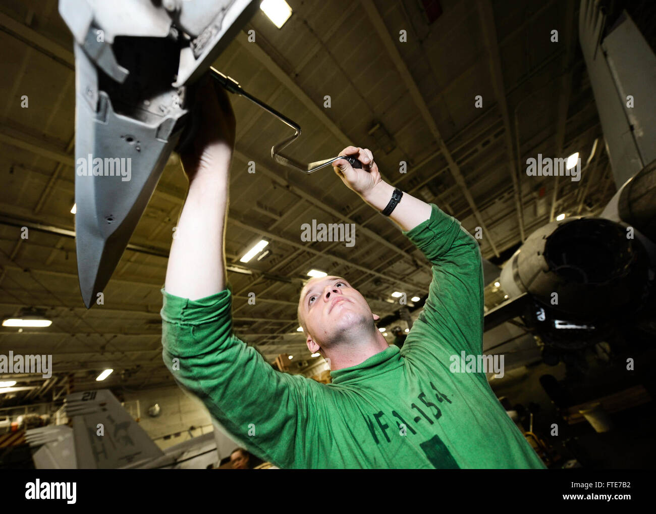 On November 5, 2013, Aviation Structural Mechanic 2nd Class Victor Olson, part of the 'Black Knights' of Strike Fighter Squadron (VFA) 154, performed maintenance on an F/A-18F Super Hornet aboard the USS Nimitz (CVN 68). Stock Photo