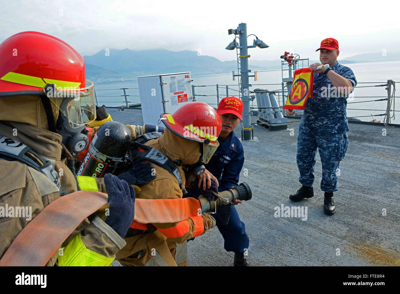 140905-N-VY489-097 GAETA, Italy (Sept. 05, 2014) Logistic Specialist 1st Class RJ Celemin, center, and Information Systems Technician 1st Class Christopher Cookson, right, damage control instructors aboard the U.S. 6th Fleet command and control ship USS Mount Whitney (LCC 20), train Sailors on firefighting procedures for a class alpha fire. Mount Whitney, homeported in Gaeta, Italy, operates with a combined crew of Sailors and Military Sealift Command civil service mariners. (U.S. Navy photo by Mass Communication Specialist 2nd Class Mike Wright/ Released) Stock Photo