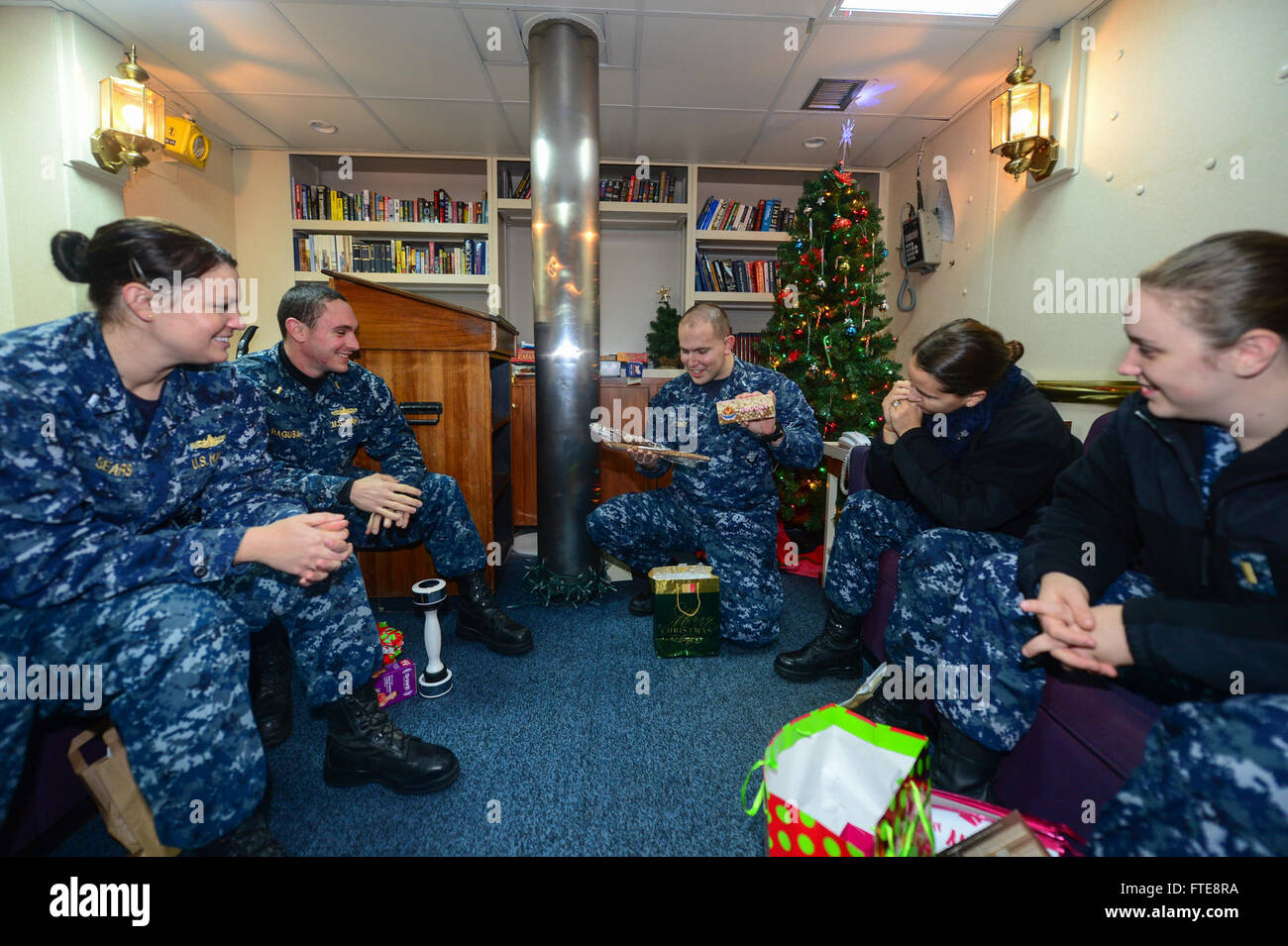 131224-N-QL471-126 FUNCHAL, Portugal (Dec. 24, 2013) Lt. j.g. Timothy Davey, navigator aboard the guided-missile cruiser USS Monterey (CG 61), hands out Christmas gifts in the ship's wardroom as the ship is moored in Funchal, Portugal for a port visit. Monterey is deployed in support of maritime security operations and theater security cooperation efforts in the U.S. 6th Fleet area of operations. (U.S. Navy photo by Mass Communication Specialist 2nd Class Billy Ho/Released) Stock Photo