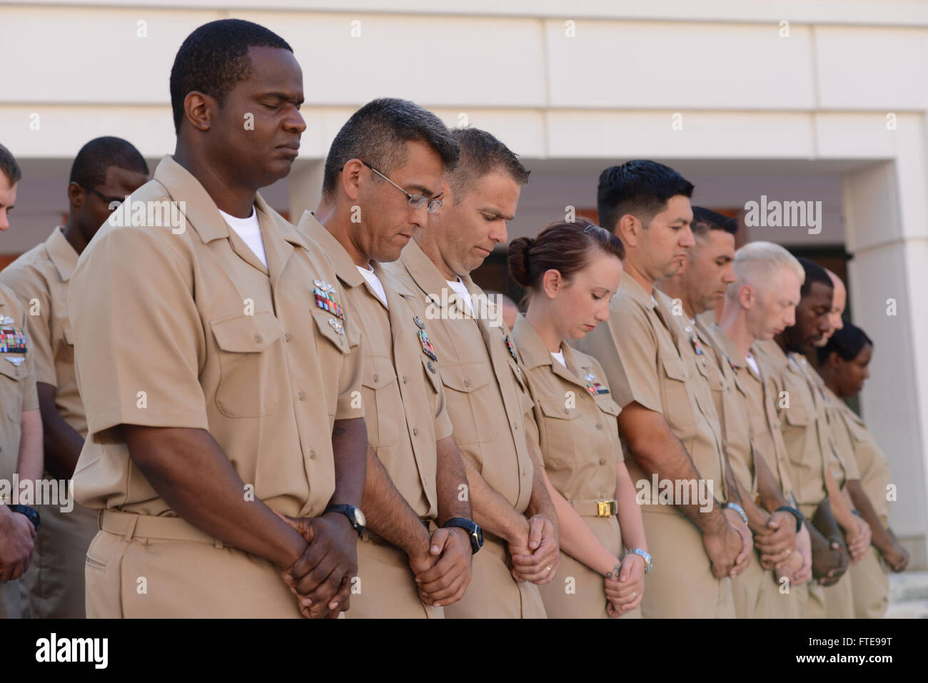 140916-N-OX801-041 NAPLES, ITALY (Sept. 16, 2014) Newly promoted chief petty officers (CPO) assigned to U.S. Naval Forces Europe-Africa/U.S. 6th Fleet stand at attention for a prayer during the CPO pinning ceremony at Naval Support Activity Naples. The ceremony honored 28 Sailors promoted to the rank of CPO, having their anchors pinned by friends, family and their new peers in the CPO Mess. (U.S. Navy photo by Mass Communication Specialist 3rd Class Daniel Schumacher/RELEASED) Stock Photo