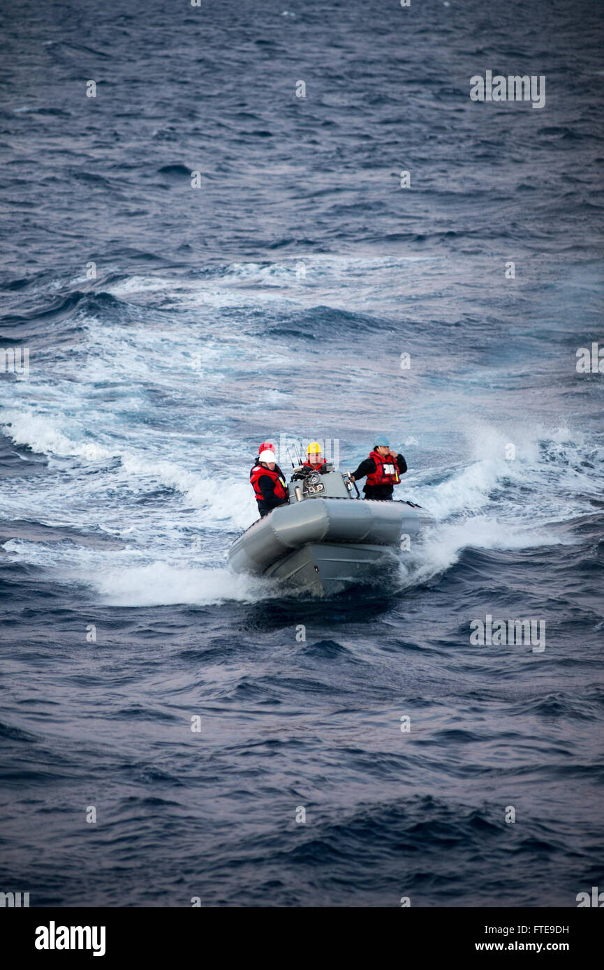 Sailors aboard the USS Stout (DDG 55) maneuver a rigid-hull inflatable ...
