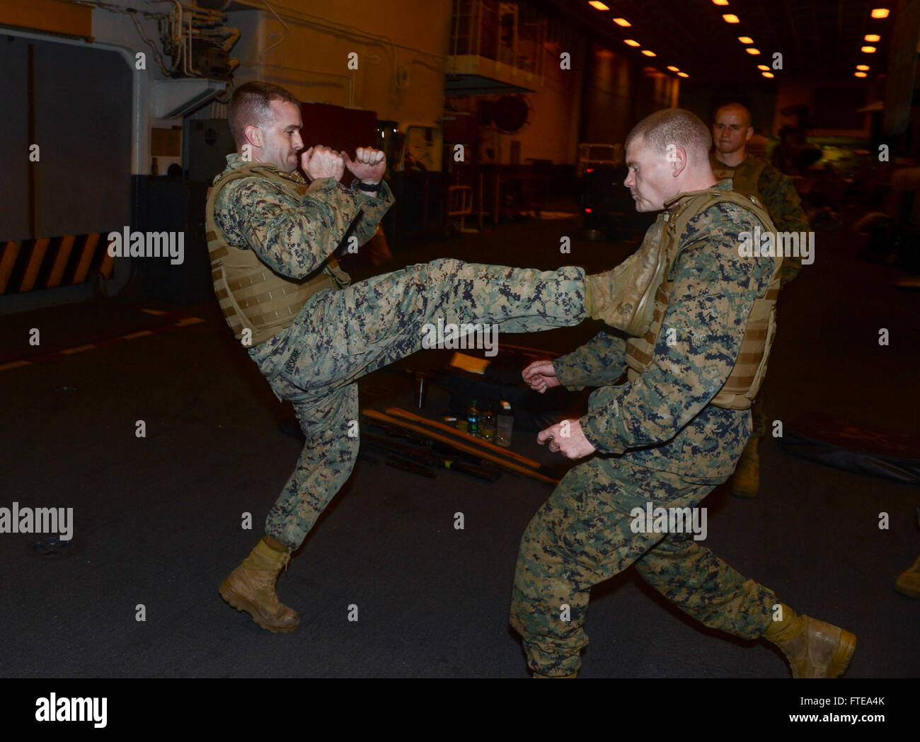 140219-N-MW280-485 ATLANTIC OCEAN (Feb. 19, 2014) --  Gunnery Sgt. Nathan Loesche, from Cincinnati, Ohio, practices Marine Corps Martial Arts Program techniques in the hangar bay aboard the multipurpose amphibious assault ship USS Bataan (LHD 5).  The Bataan Amphibious Readiness Group is deployed supporting maritime security operations, providing crisis response capability, increasing theater security cooperation and a forward naval presence in the U.S. Navy's 5th and 6th Fleet Area of Responsibility. (U.S. Navy Photo by Mass Communication Specialist 3rd Class Chase Hawley/Released) Stock Photo