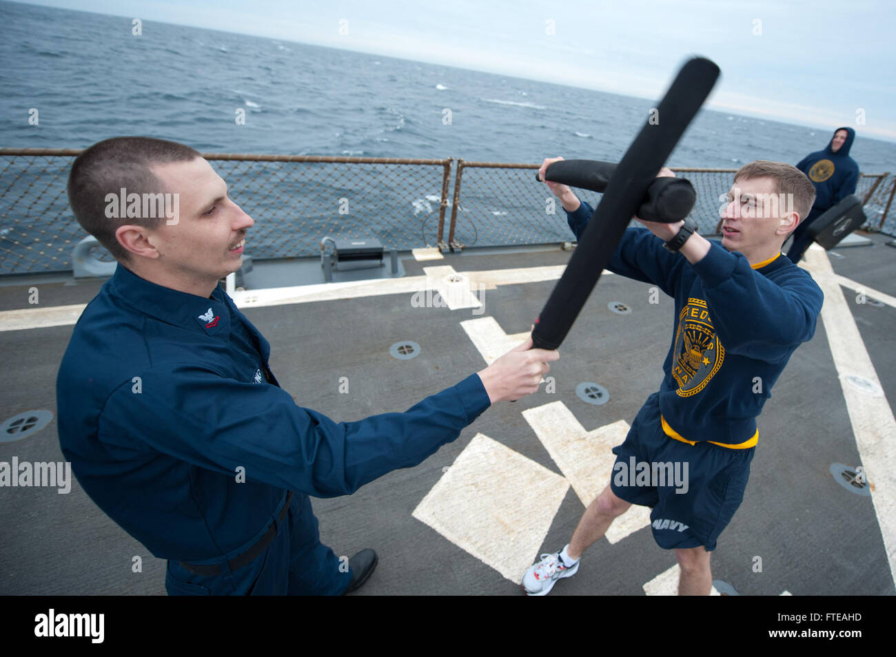 140228-N-WD757-399 MEDITERRANEAN SEA (FEB. 28, 2014) – Lt. j.g. Alexander Spalding defends himself against a simulated attacker after being sprayed with oleoresin capsicum (OC) during an OC spray qualification course aboard the guided-missile destroyer USS Arleigh Burke (DDG 51). Arleigh Burke is on a scheduled deployment in support of maritime security operations and theater security cooperation efforts in the U.S. 5th and 6th Fleet area of responsibility. (U.S. Navy photo by Mass Communication Specialist 2nd Class Carlos M. Vazquez II/Released)  Join the conversation on Twitter ( https://twi Stock Photo