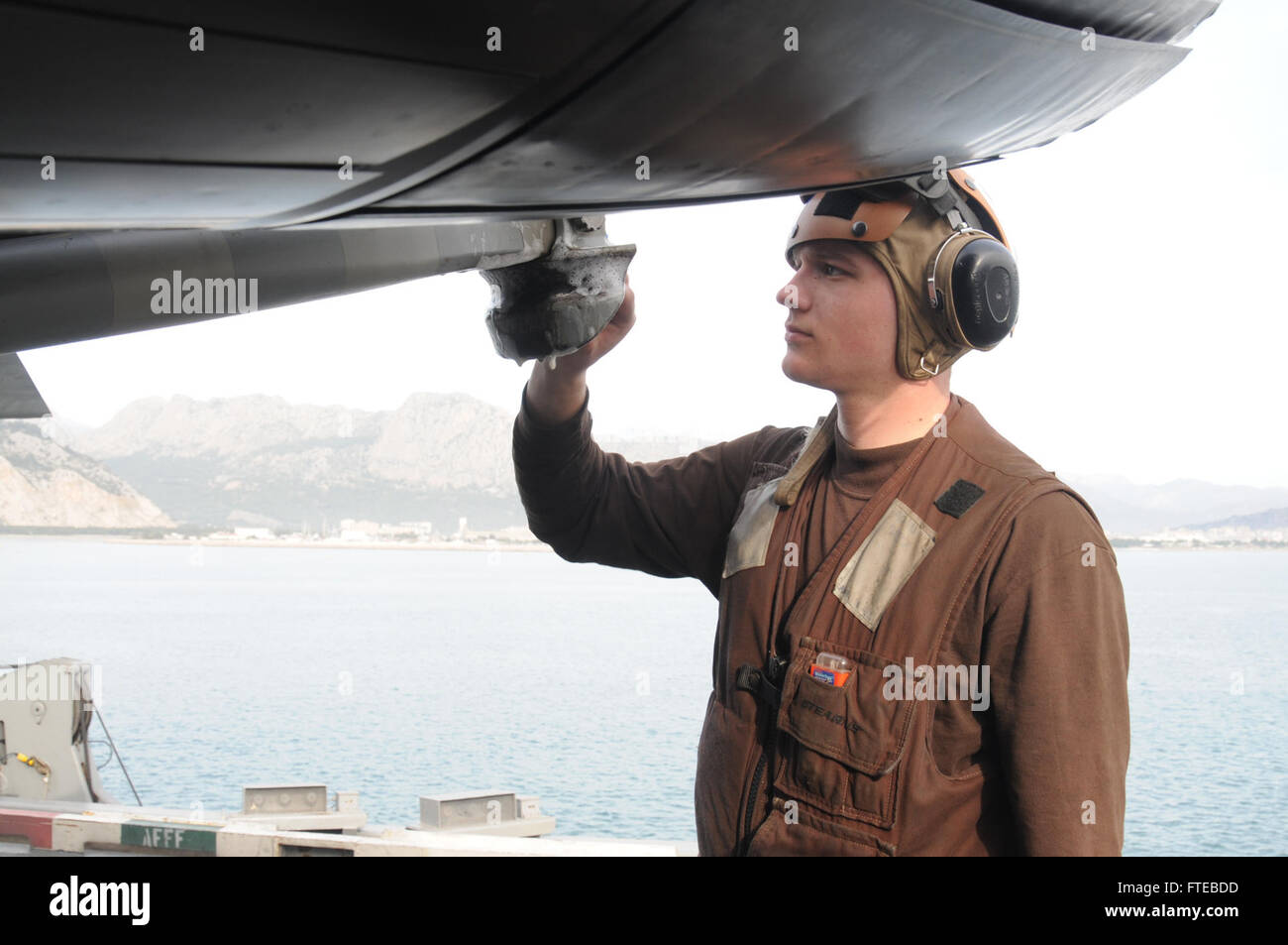 140309-N-EF845-007 ANTALYA, Turkey (Mar. 9, 2014) Aviation Ordinanceman Airman Alex Beeck, from Courtland, Minn.,  assigned to the “Fighting Black Lions” of Strike Fighter Squadron (VFA) 213, cleans a tail hook of a F/A-18F Super Hornet  aboard the aircraft carrier USS George H.W. Bush (CVN 77). George H. W. Bush is on a scheduled deployment supporting maritime security operations and theater security cooperation efforts in the U.S. 6th Fleet area of operations.  (U.S. Navy photo by Mass Communication Specialist 3rd Class Jeffrey Madlangbayan/Released) Stock Photo