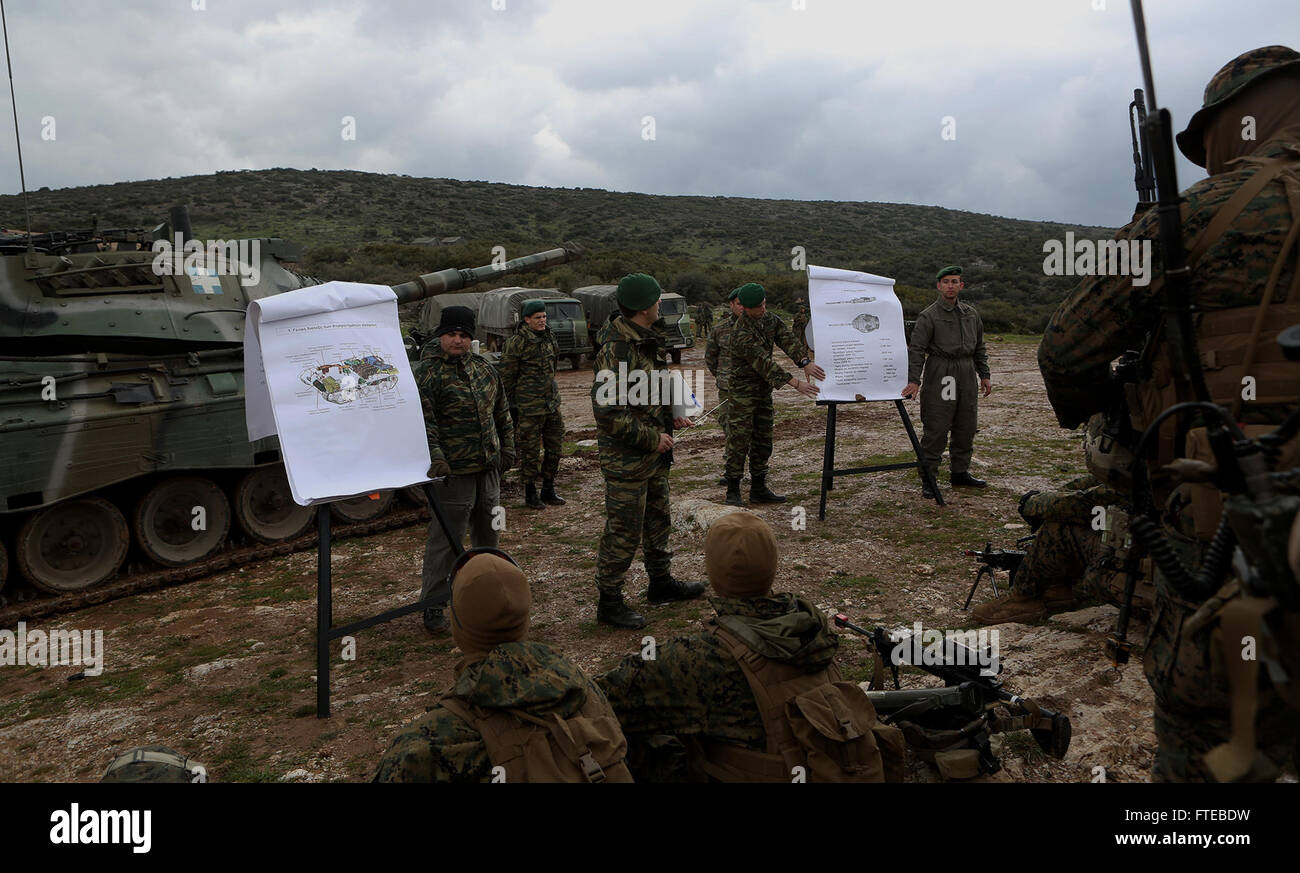 A photograph from a U.S.-Greece joint military exercise, showing a member of the Hellenic Army briefing U.S. Marines on the M185 Main Battle Tank. The exercise is part of ongoing bilateral defense cooperation between the two nations. Stock Photo