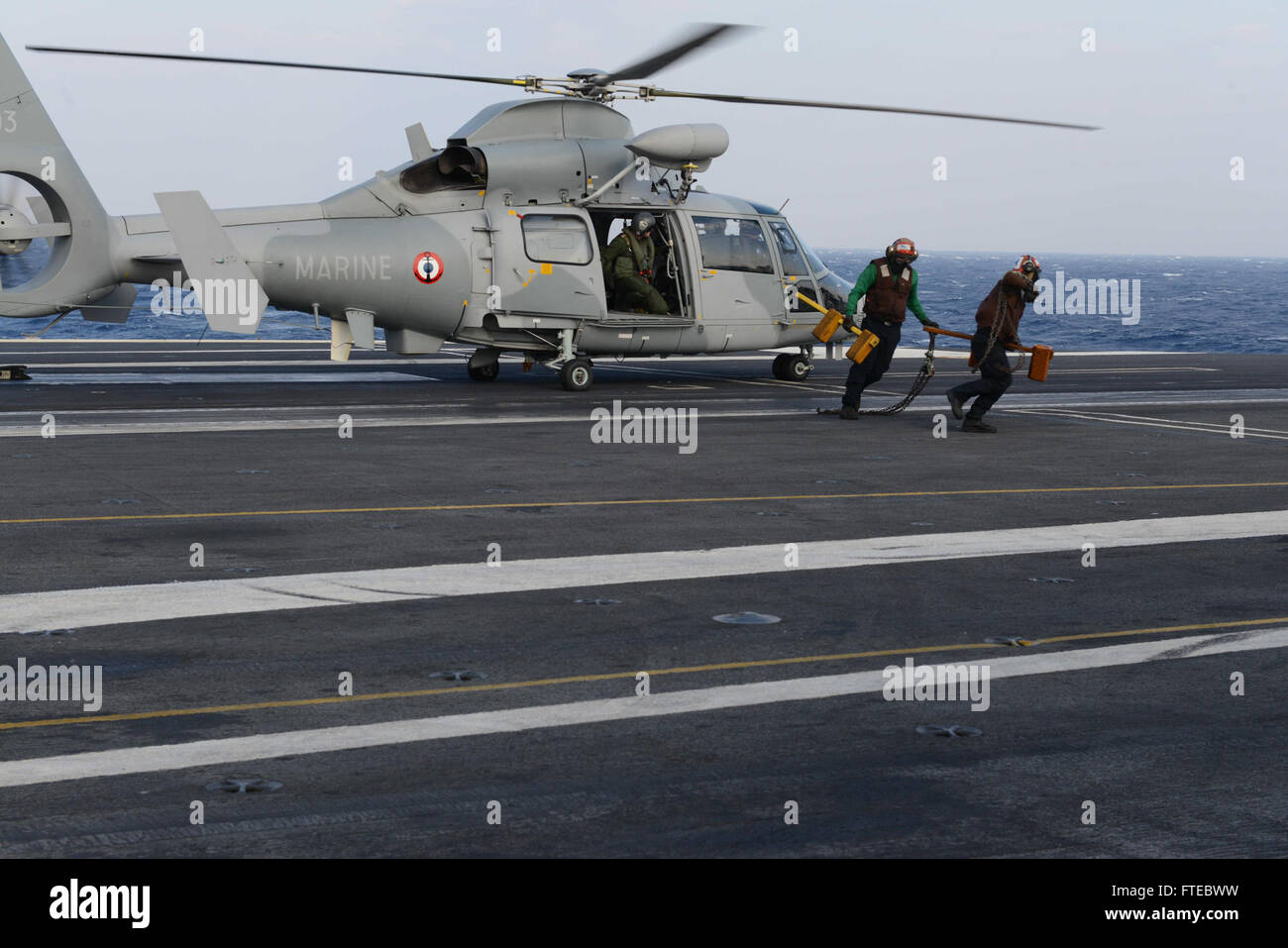 140313-N-HK946-006 MEDDITERANEAN SEA (Mar. 13, 2014) Sailors on the flight deck of the aircraft carrier USS George H.W. Bush (CVN 77) remove chocks and chains from an AS565 Panther helicopter as it prepares to take off during a scheduled exercise. George H. W. Bush is on a scheduled deployment supporting maritime security operations and theater security cooperation efforts in the U.S. 6th Fleet area of operations.  (U.S. Navy photo by Mass Communication Seaman Travis Litke/Released) Stock Photo