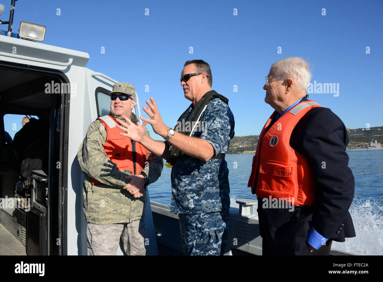 140217-N-JE710-046 SOUDA BAY, Greece (Feb. 17, 2014) – U.S. Naval Support Activity Souda Bay Commanding Officer, Capt. James F. Gibson, middle, briefs CAPSTONE participants on support capabilities during a boat tour of Souda Bay.  CAPSTONE is a joint military education program for officers promoted to Rear Admiral and Brigadier General or civilians newly appointed to Senior Executive Service. (U.S. Navy photo by Mass Communication Specialist 2nd Class Jeffrey M. Richardson/Released)  Join the conversation on Twitter ( https://twitter.com/naveur navaf )  follow us on Facebook ( https://www.face Stock Photo