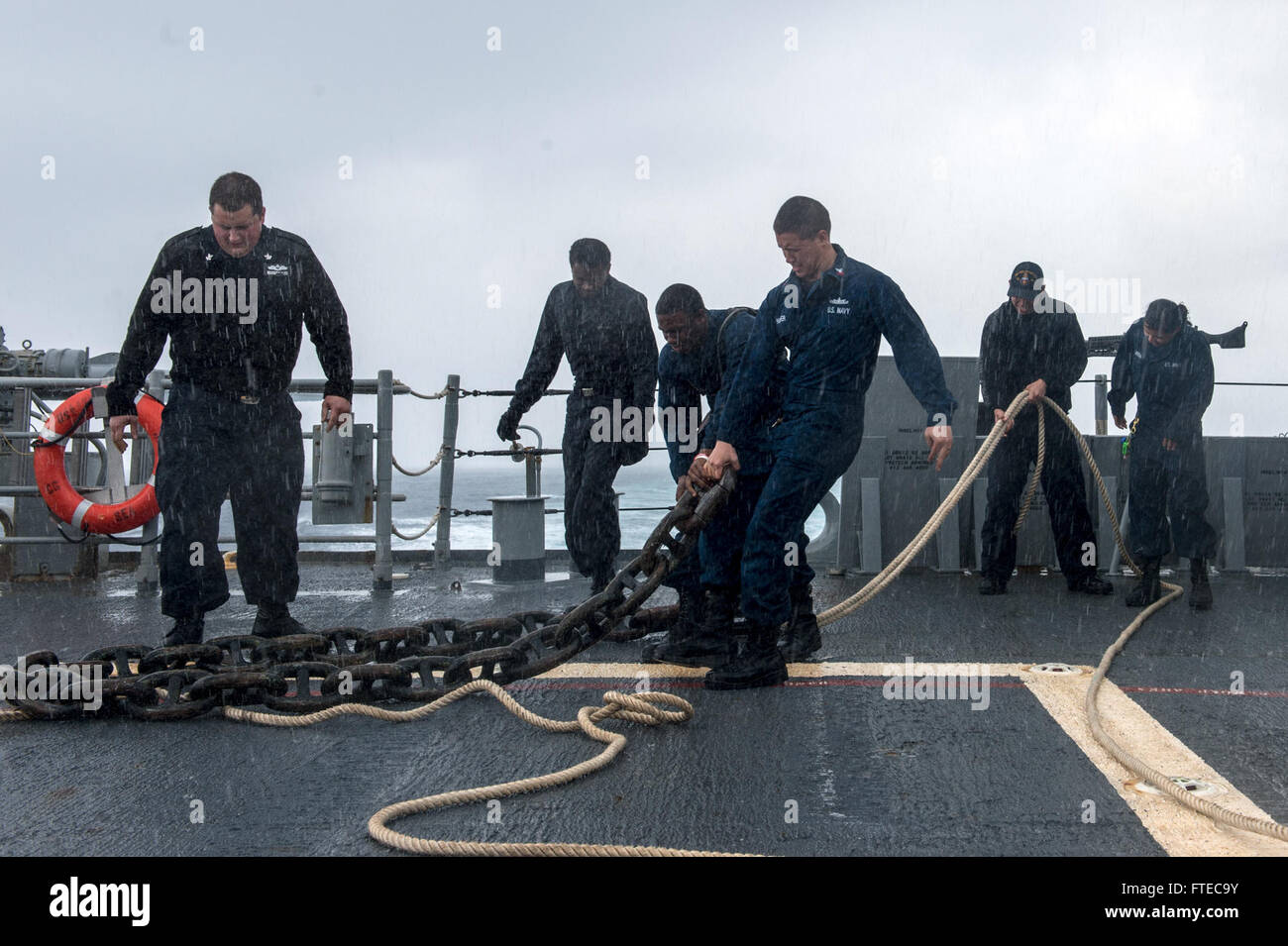 1400317-N-PJ969-241 MEDITERRANEAN SEA (March 17, 2014) Sailors heave an anchor chain across the deck of the guided-missile cruiser USS Philippine Sea (CG 58). Philippine Sea is on a scheduled deployment supporting maritime security operations and theater security cooperation efforts in the U.S. 6th Fleet area of operations. (U.S. Navy photo by Mass Communication Specialist 3rd Class Abe McNatt/Released) Stock Photo