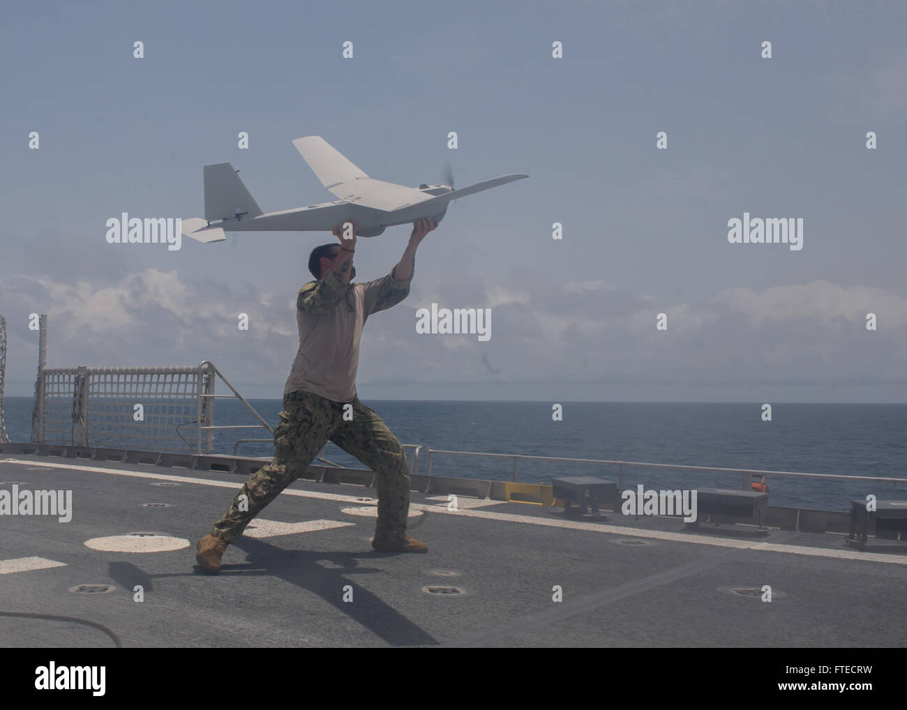 140327-N-ZY039-012  GULF OF GUINEA (March 27, 2014) - Fire Controlman 2nd Class Dustin Gower assigned to the PUMA unmanned aerial vehicle (UAV) detachment aboard joint, high-speed vessel USNS Spearhead (JHSV 1) throws a UAV during flight operationsas part of a U.S.-Ghana combined maritime law enforcement operation under the African Maritime Law Enforcement Partnership (AMLEP) program. AMLEP, the operational phase of Africa Partnership Station (APS), brings together U.S. Navy, U.S. Coastguard, and respective Africa partner maritime forces to actively patrol that partner's territorial waters and Stock Photo