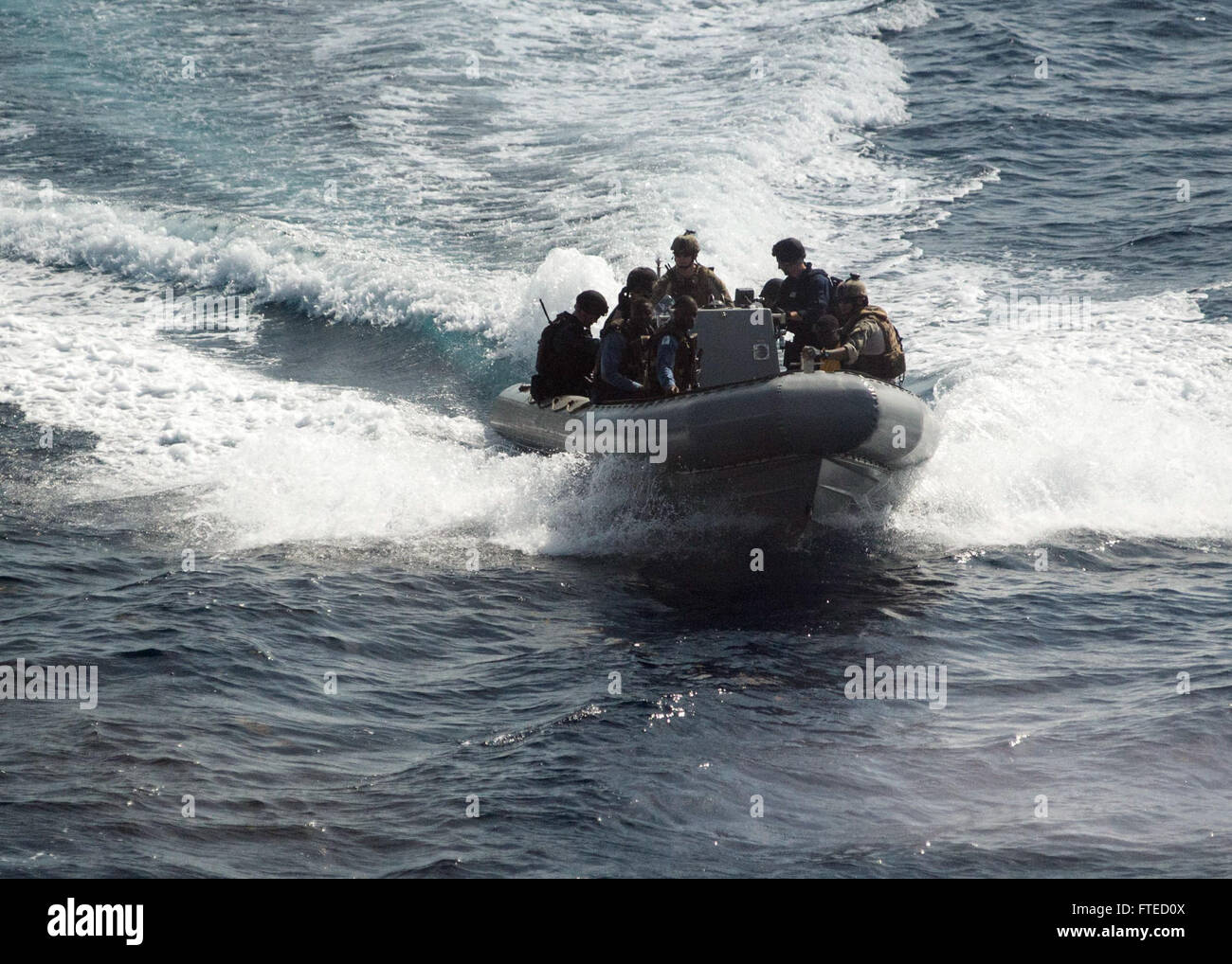 GULF OF GUINEA (April 1, 2014) - U.S. Sailors, U.S. Coast Guardsmen and members of various Ghanaian maritime forces, all embarked aboard joint, high-speed vessel USNS Spearhead (JHSV 1) operate in a rigid-hull inflatable boat (RHIB) during a document verification operation as part of a U.S.-Ghana combined maritime law enforcement operation under the African Maritime Law Enforcement Partnership (AMLEP) program. AMLEP, the operational phase of Africa Partnership Station (APS), brings together U.S. Navy, U.S. Coastguard, and respective Africa partner maritime forces to actively Stock Photo