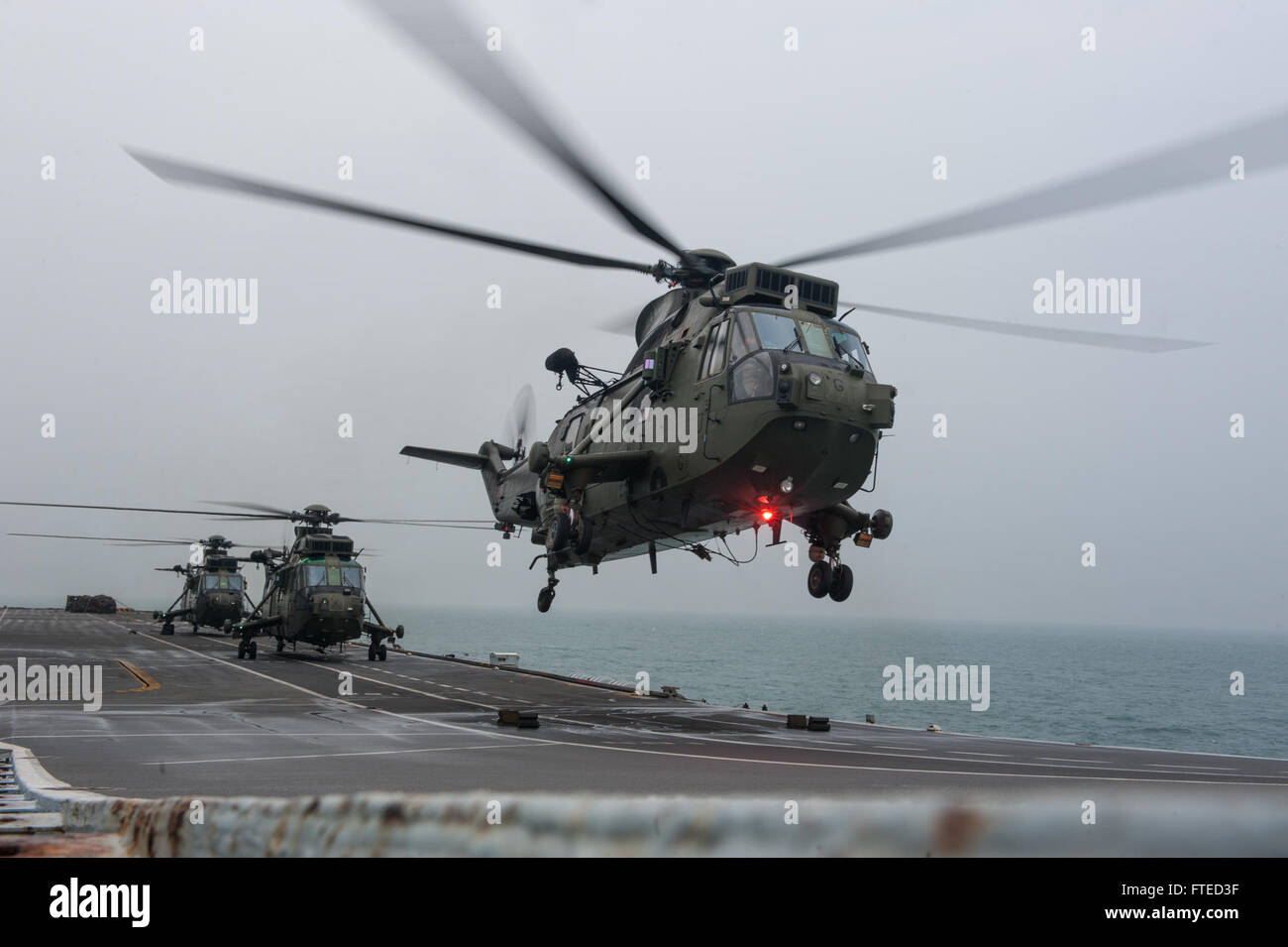 140403-N-WX580-141 NORTH SEA (Apr. 3, 2014) An Seaking Helicopter from 843 Naval Air Squadron  departs the Royal Navy aircraft carrier HMS Illustrious (R06) during exercise Joint Warrior 14-1.  Joint Warrior 14-1 is a semi-annual, United Kingdom led training exercise designed to provide NATO and allied forces a unique multi-warfare environment in which to prepare for global operations. The Joint Warrior exercise is intended to improve interoperability between allied navies in an operational challenging environment. (U.S. Navy photo by Mass Communication Specialist 3rd Class Lacordrick Wilson/R Stock Photo