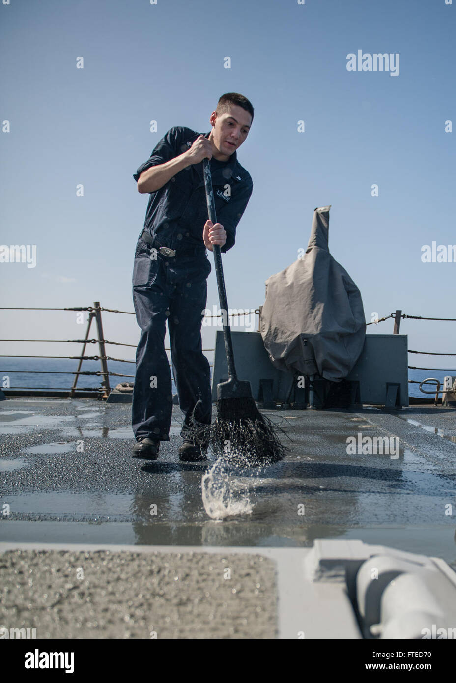140408-N-EI510-044 MEDITERRANEAN SEA (April 08, 2014) -Interior Communications Electrician 3rd Class Eric Larose, from Tampa, Fla., participates in a fresh water wash down aboard the Arleigh Burke-class guided-missile destroyer USS Truxtun (DDG 103). Truxtun is deployed as part of the George H.W. Bush Carrier Strike Group on a scheduled deployment supporting maritime security operations and theater security cooperation efforts in the U.S. 5th Fleet area of responsibility. (U.S. Navy photo by Mass Communication Specialist 3rd Class Scott Barnes/Released) Stock Photo