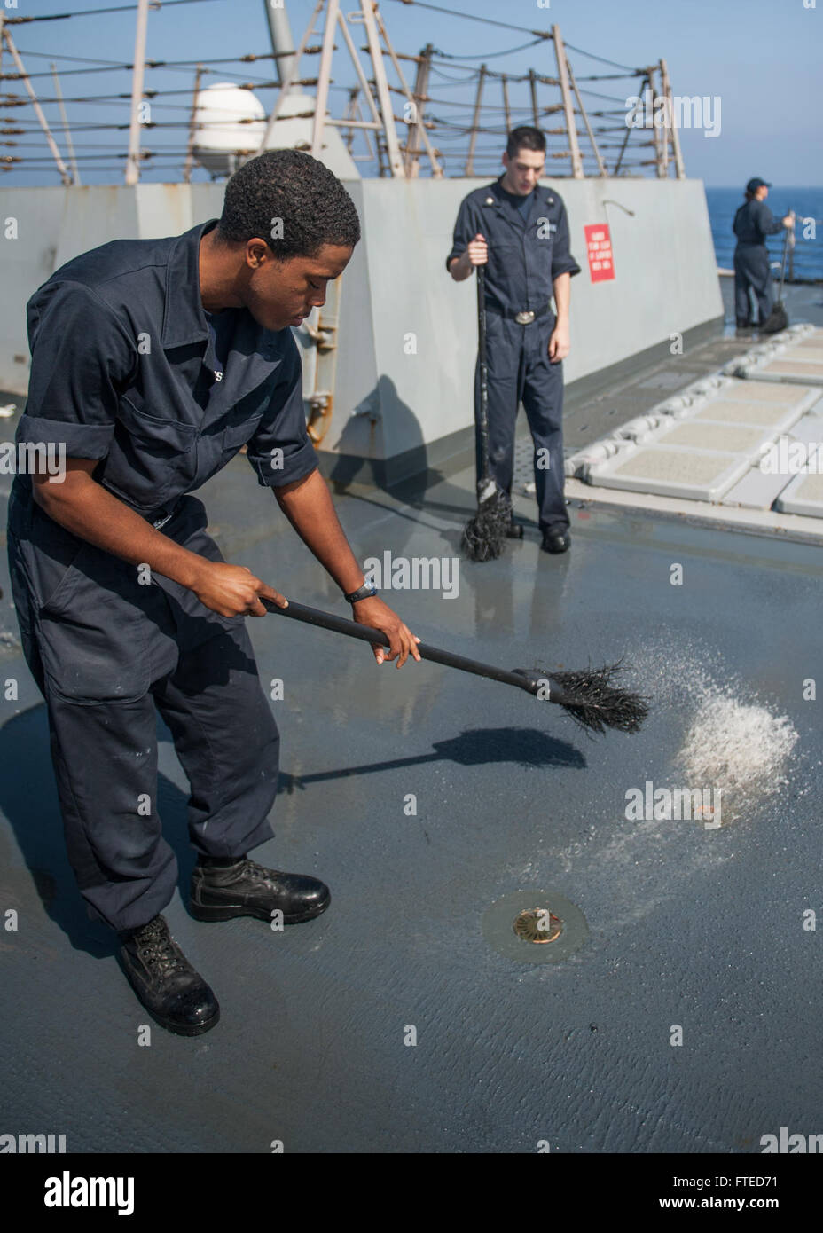 140408-N-EI510-061 MEDITERRANEAN SEA (April 08, 2014) - Sonar Technician (Surface) Seaman Apprentice Gregory Harris, from Lancaster, Texas, participates in a fresh water wash down aboard the Arleigh Burke-class guided-missile destroyer USS Truxtun (DDG 103). Truxtun is deployed as part of the George H.W. Bush Carrier Strike Group on a scheduled deployment supporting maritime security operations and theater security cooperation efforts in the U.S. 5th Fleet area of responsibility. (U.S. Navy photo by Mass Communication Specialist 3rd Class Scott Barnes/Released) Stock Photo