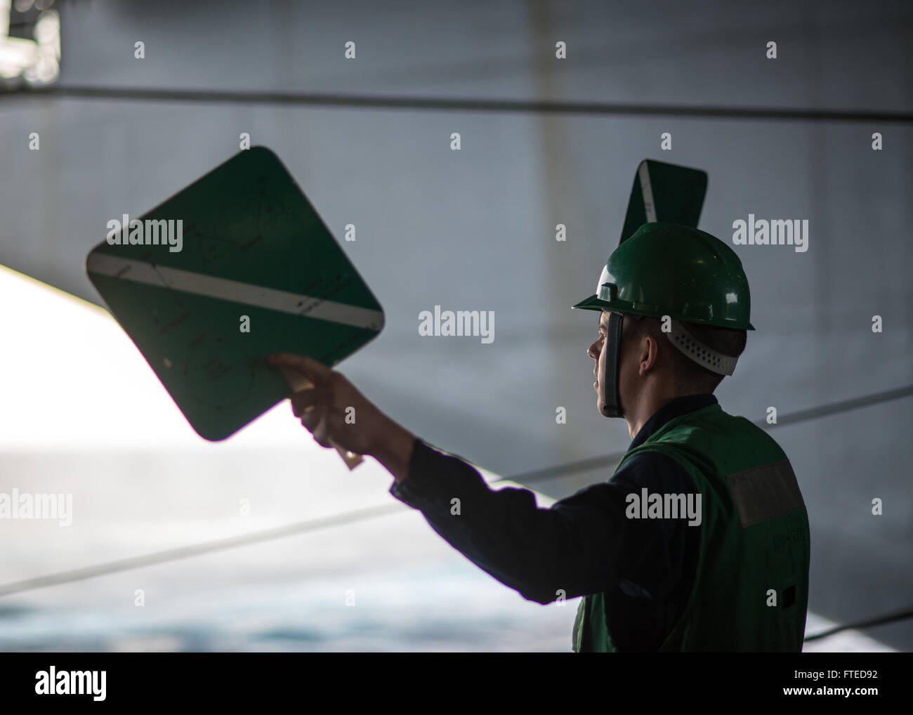 140409-N-LH273-106 ATLANTIC OCEAN (April 9, 2014) Seaman Maverick Melton serves as a signalman in the hangar bay of aircraft carrier USS Harry S. Truman (CVN 75) during a replenishment-at-sea. Harry S. Truman, flagship of Harry S. Truman Carrier Strike Group, is deployed conducting maritime security operations and supporting theater security cooperation efforts as it completes a 9-month deployment to the U.S. 6th and 5th Fleet areas of responsibility. (U.S. Navy photo by Mass Communication Specialist 2nd Class Adam Brock/Released) Stock Photo