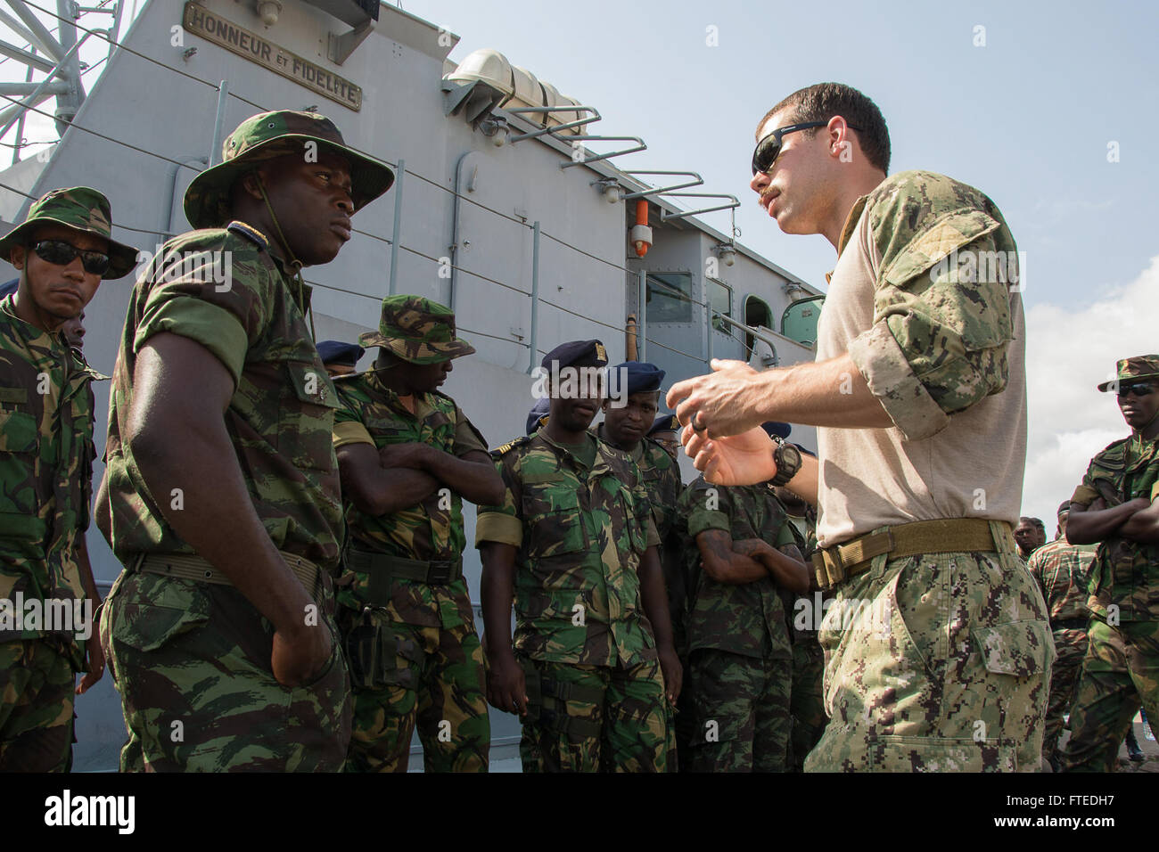 DOUALA, Cameroon--Ensign Maiquel Madre Deus, Sao Tome and Principe team  leader, talks with Petty Officer 2nd Class Marcus Leon before conducting  boarding procedure familiarization in Douala, Cameroon as part of exercise  Obangame
