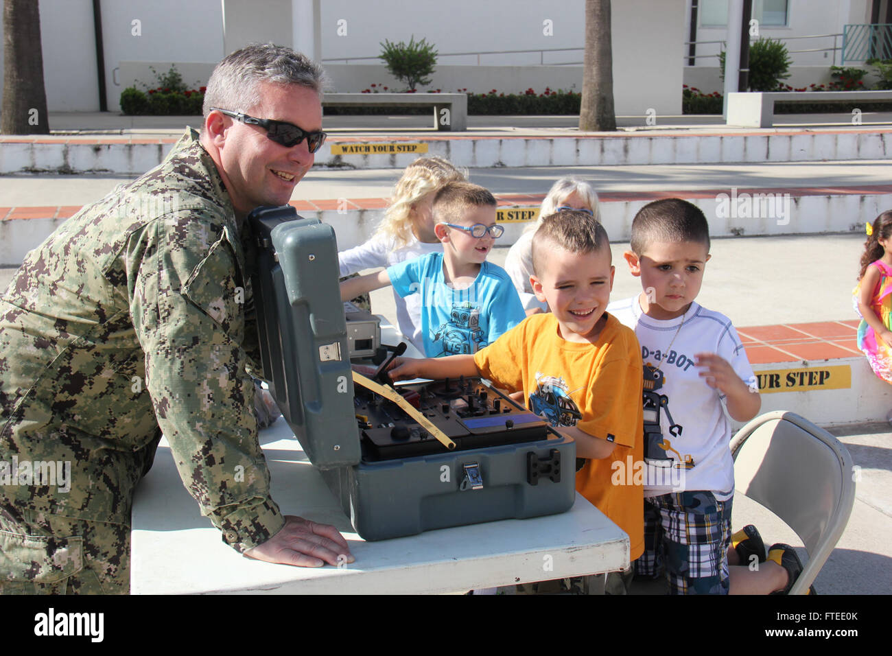 140423-N-ZZ999-005: ROTA, Spain (April 23, 2014) – Lt. Aaron Holdren, assigned to Explosive Ordnance Disposal Mobile Unit (EODMU) 8, shows students from David Glasgow Farragut Elementary School how to operate the Talon ordnance disposal robot controller. EODMU 8, homeported in Rota, supports maritime security operations and theater security cooperation efforts in the U.S. 6th Fleet area of operations. (U.S. Navy photo/Released) Stock Photo