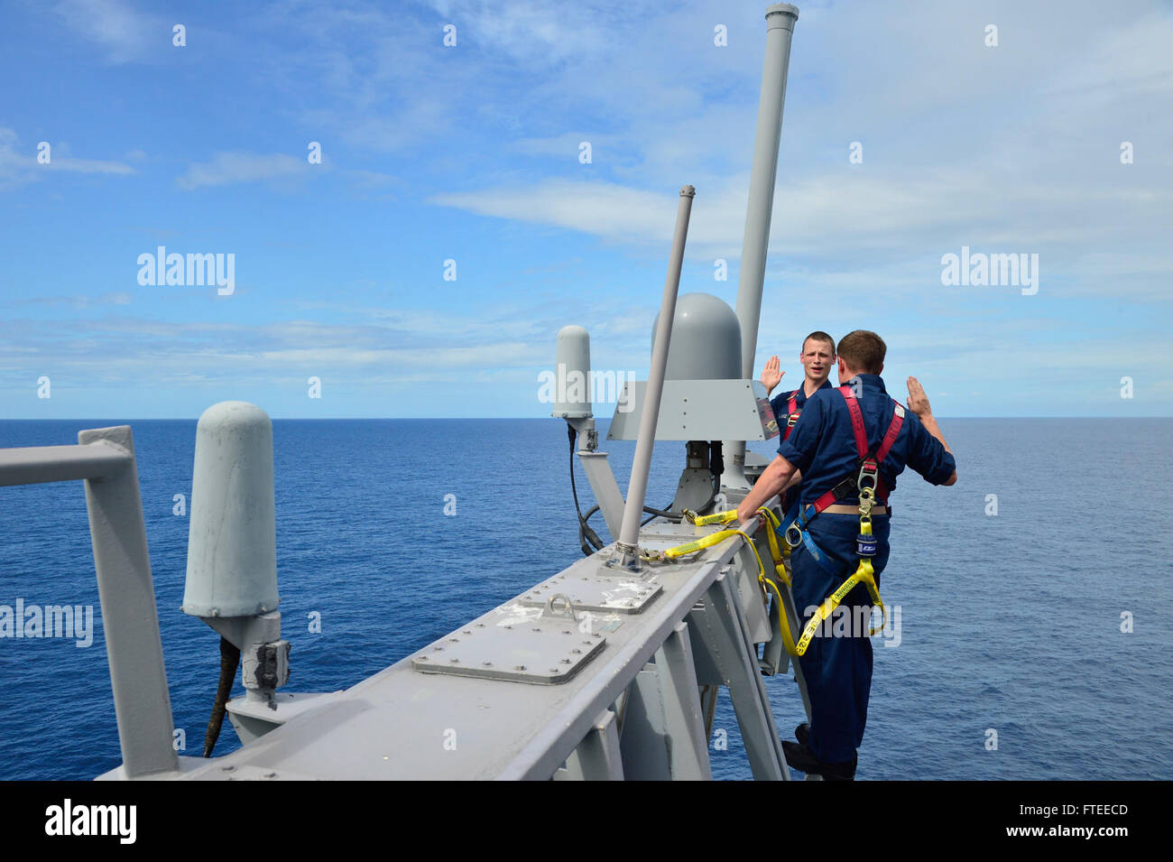 140520-N-AT101-744: INDIAN OCEAN (May 20, 2014) – Electronics Technician 2nd Class Max Lanz, left, recites the oath of reenlistment on the 0-9 level of the guided-missile destroyer USS Nitze (DDG 94). Nitze, homeported in Norfolk, Va., is on a scheduled deployment supporting maritime security operations and theater security cooperation efforts in the U.S. 6th Fleet area of operations. (U.S. Navy photo by Mass Communication Specialist 1st Class Maddelin Angebrand/Released) Stock Photo