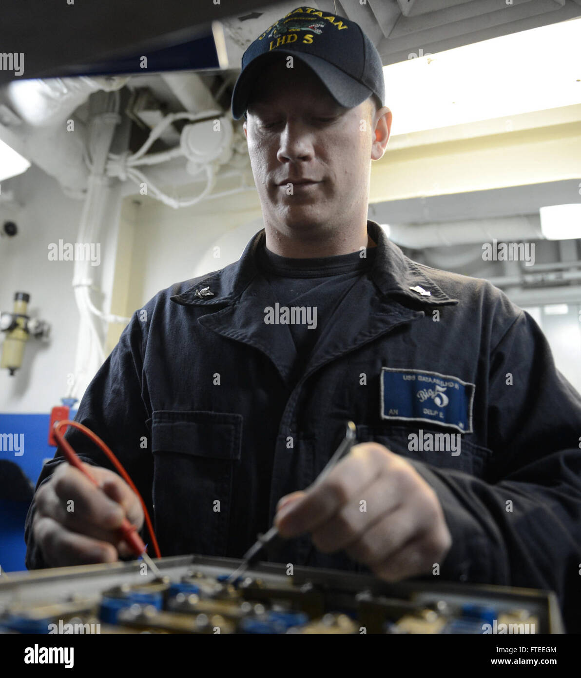 140528-N-MW280-094: MEDITERRANEAN SEA (May 28, 2014) - Aviation Electrician's Mate 3rd Class Erick Delp tests cell voltage in an aviation battery for an MV-22 Osprey aboard the multipurpose amphibious assault ship USS Bataan (LHD 5). Bataan, with elements of the 22nd Marine Expeditionary Unit, is operating in the in U.S. 6th Fleet area of operations to augment U.S. Crisis Response forces in the region. (U.S. Navy photo by Mass Communication Specialist 3rd Class Chase Hawley/Released) Join the conversation on Twitter ( https://twitter.com/naveur navaf )  follow us on Facebook ( https://www.face Stock Photo