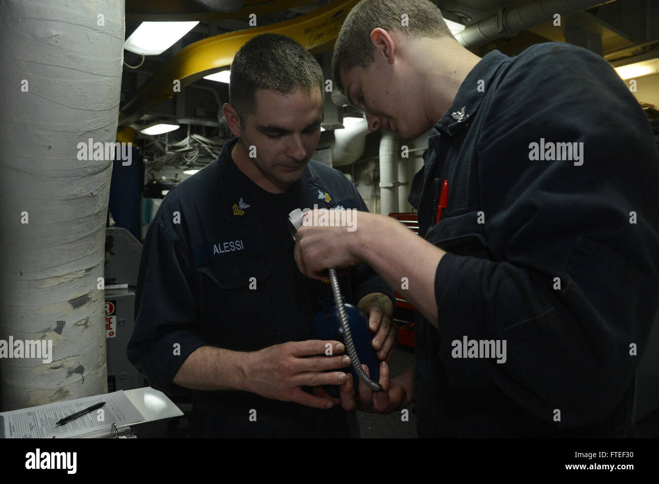 140616-N-MW280-381 MEDITERRANEAN SEA (June 16, 2014) -- Machinist's Mate 1st Class Jared Alessi, from Buffalo, N.Y., supervises a spot check performed by Machinist's Mate 3rd Class Jordan Gilling, from Saginaw, Mich., in the assault shop aboard the multipurpose amphibious assault ship USS Bataan (LHD 5). Bataan, with elements of the 22nd Marine Expeditionary Unit, is operating in the U.S. 6th Fleet area of operations to augment U.S. Crisis Response forces in the region.  (U.S. Navy photo by Mass Communication Specialist 3rd Class Chase Hawley/Released) Stock Photo