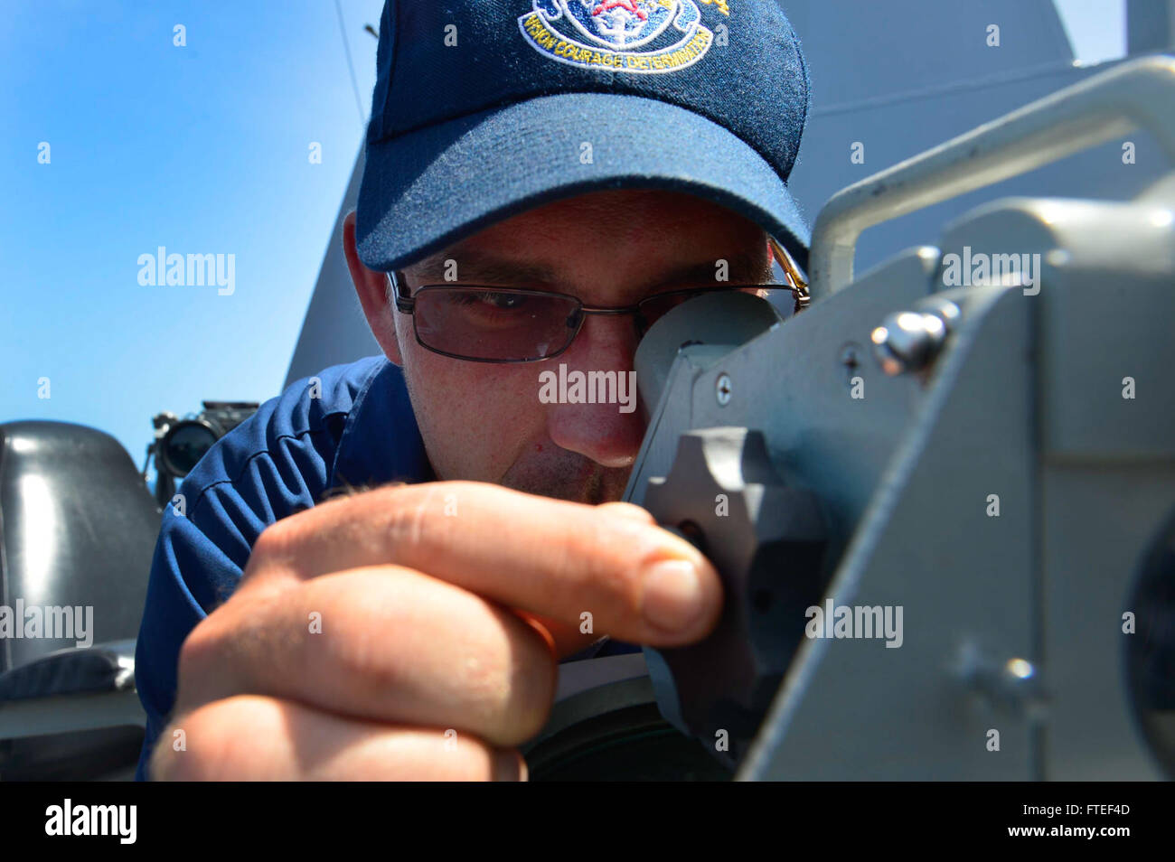 140622-N-AT101-003  INDIAN OCEAN (June 22, 2014) – Quarter Master 1st Class Shawn Dekle, assigned to the guided-missile destroyer USS Nitze (DDG 94), looks through telescopic alidade on the bridge wing as the ship navigates the Indian Ocean.  Nitze, homeported in Norfolk, Va., is conducting naval operations in the U.S. 6th Fleet area of operations in support of U.S. national security interests in Africa. (U.S. Navy photo by Mass Communication Specialist 1st Class Maddelin Angebrand)  Join the conversation on Twitter ( https://twitter.com/naveur navaf )  follow us on Facebook ( https://www.face Stock Photo