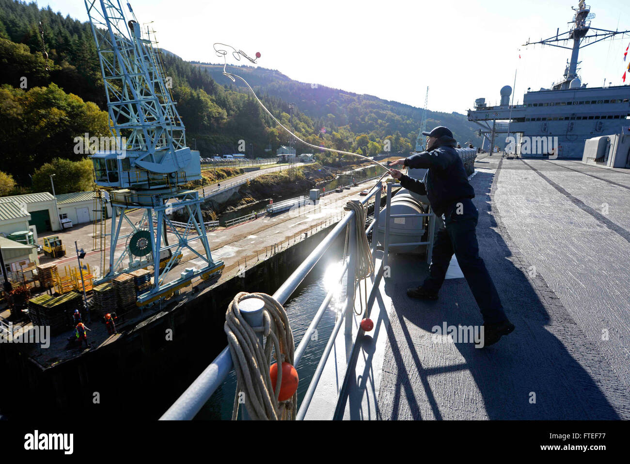 151017-N-VY489-189 GLENMALLAN, Scotland (Oct. 17, 2015) Civilian mariner able body seaman Aaron Mcclister throws a shot line to the pier as the U.S. 6th Fleet command and control ship USS Mount Whitney (LCC 20) is arrives in Glenmallan, Scotland, for a scheduled port visit. Mount Whitney, forward deployed to Gaeta, Italy, operates with a combined crew of Sailors and Military Sealift Command civil service mariners. (U.S. Navy photo by Mass Communication Specialist 1st Class Mike Wright/ Released) Stock Photo