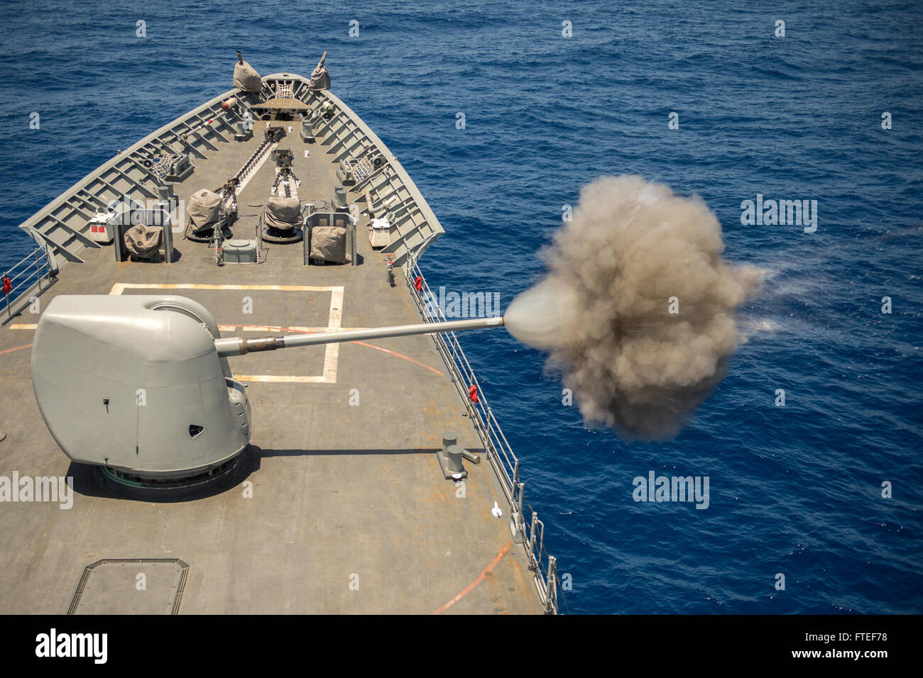 The USS Vella Gulf (CG 72), a Ticonderoga-class guided-missile cruiser, fires its 5-inch gun during a pre-action calibration in the Mediterranean Sea, conducting operations to enhance security and stability in Europe. Stock Photo