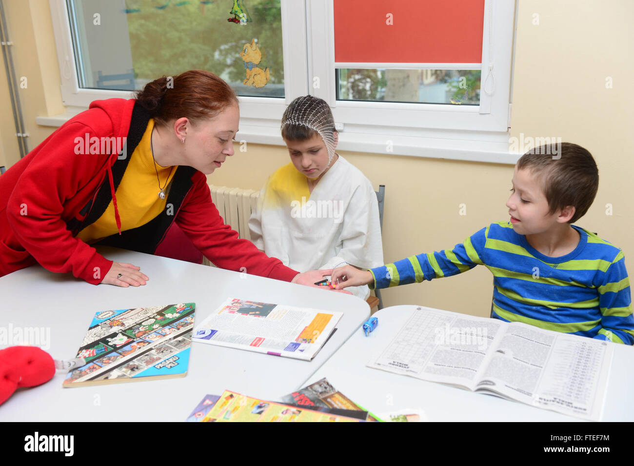 140629-N-YO152-007 RIGA, Latvia (June 29, 2014) Logistics Specialist 2nd Class Alisha Klippert shows Naval ribbons to children during a community relations visit at a children's hosptial while in port in Riga, Latvia. Oscar Austin, homeported in Norfolk, Va., is on a scheduled deployment supporting maritime security operations and theater security cooperation efforts in the U.S. 6th Fleet area of operations. (U.S. Navy photo by Mass Communication Specialist 3rd Class (SW) DJ Revell/released) Stock Photo