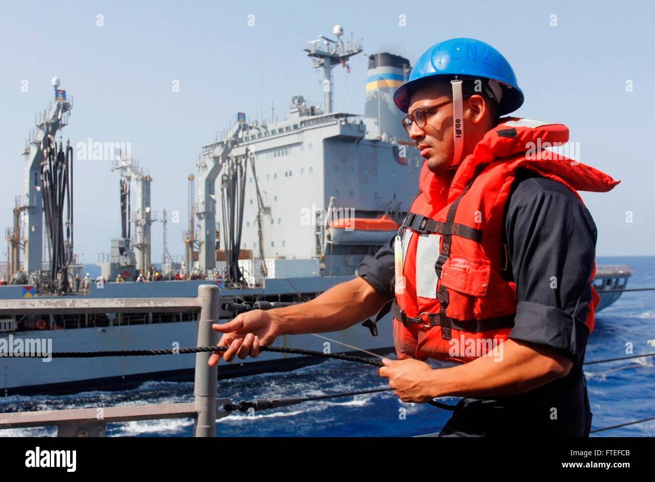 140727-N-KT328-003  MEDITERRANEAN (July 27, 2014) – Personnel Specialist 2nd Class Noe Garcia hauls in the station to station phone line aboard the guided-missile frigate USS Samuel B. Roberts (FFG-58) during a replenishment-at-sea with replenishment oiler USNS Patuxent (T-AO-201). Samuel B. Roberts, homeported in Mayport, Fla., is conducting naval operations in the U.S. 6th Fleet area of operations in support of U.S. national security interests in Europe and Africa. (U.S. Navy photo by Ensign Evan Albright) Stock Photo
